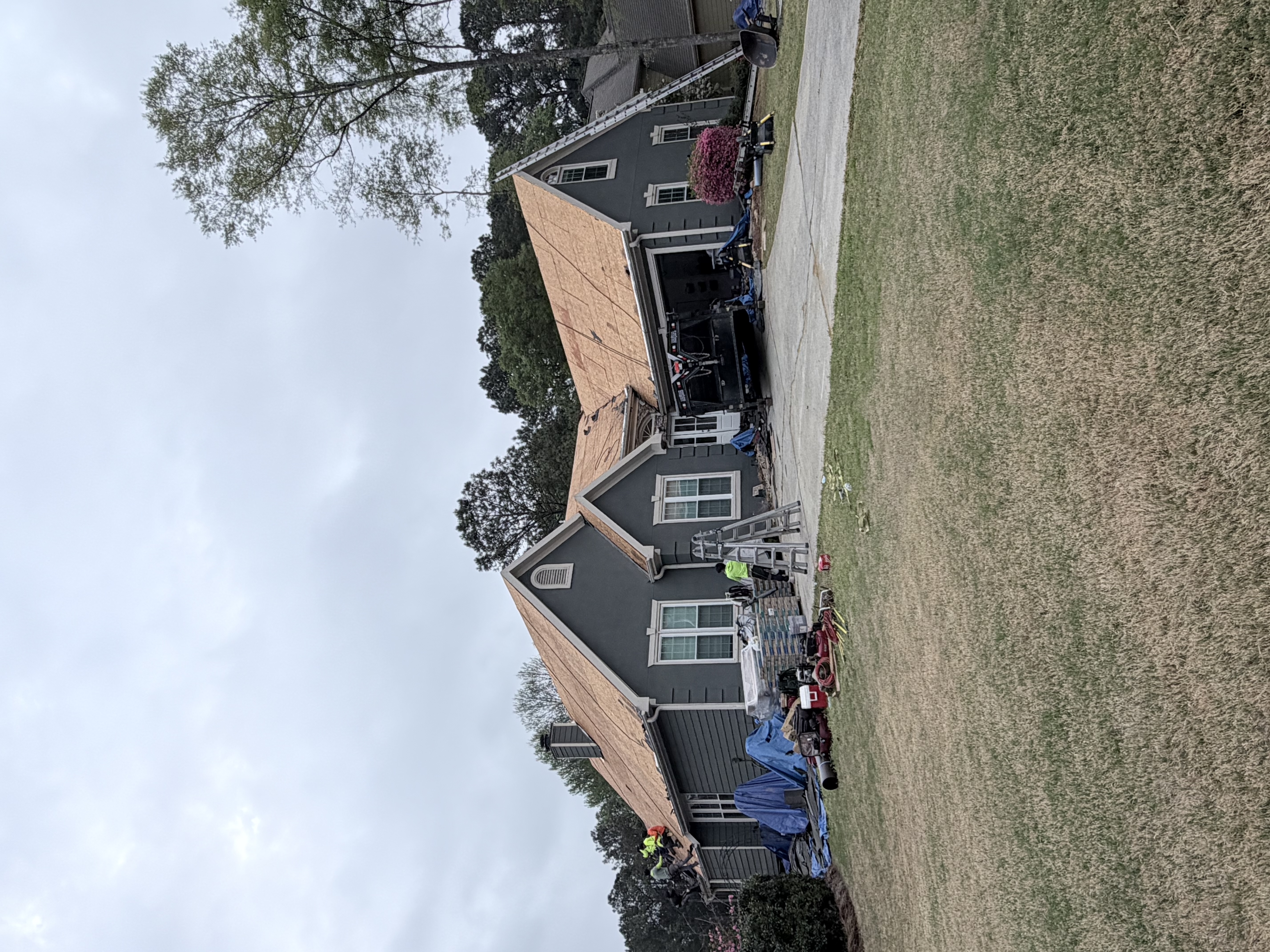 Finished gray shingle roof on stone and stucco estate home
